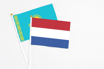 Netherlands and Kazakhstan stick flags on white background. High quality fabric, miniature national flag. Peaceful global concept.White floor for copy space.