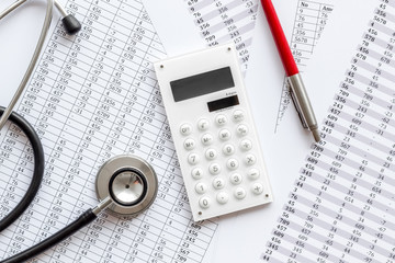 Health insurance concept. Stethoscope near financial documents and calculator top view