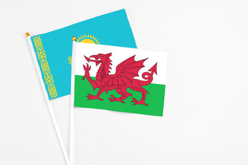 Wales and Kazakhstan stick flags on white background. High quality fabric, miniature national flag. Peaceful global concept.White floor for copy space.