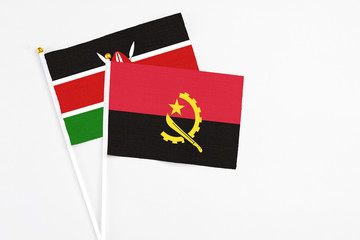 Angola and Kenya stick flags on white background. High quality fabric, miniature national flag....