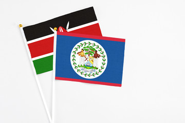Belize and Kenya stick flags on white background. High quality fabric, miniature national flag. Peaceful global concept.White floor for copy space.