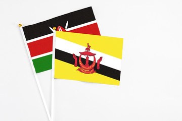 Brunei and Kenya stick flags on white background. High quality fabric, miniature national flag. Peaceful global concept.White floor for copy space.