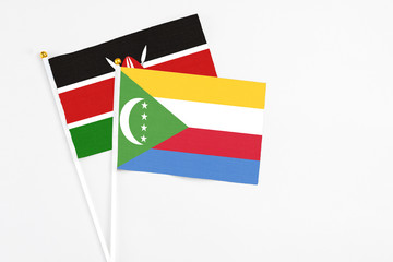 Comoros and Kenya stick flags on white background. High quality fabric, miniature national flag. Peaceful global concept.White floor for copy space.