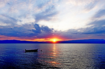 Boat in scarlet sunset on Ohrid Lake in September