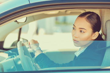 Serious young female person driving her auto