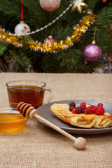 Homemade pancakes filled with cottage cheese, honey in a bowl and a cup of tea