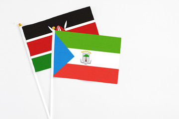 Equatorial Guinea and Kenya stick flags on white background. High quality fabric, miniature national flag. Peaceful global concept.White floor for copy space.