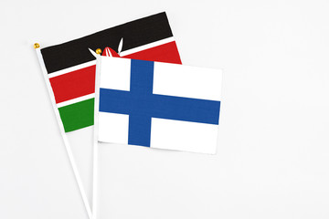 Finland and Kenya stick flags on white background. High quality fabric, miniature national flag. Peaceful global concept.White floor for copy space.