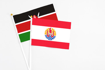 French Polynesia and Kenya stick flags on white background. High quality fabric, miniature national flag. Peaceful global concept.White floor for copy space.