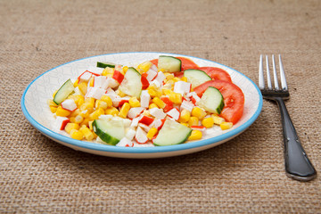 Salad with crab sticks, boiled corn and freshly sliced tomato and cucumber