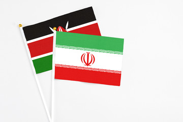 Iran and Kenya stick flags on white background. High quality fabric, miniature national flag. Peaceful global concept.White floor for copy space.