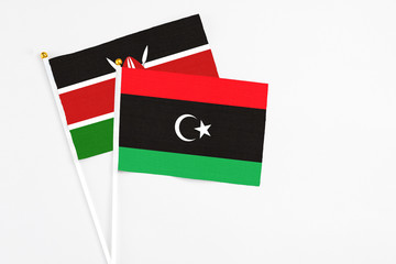 Libya and Kenya stick flags on white background. High quality fabric, miniature national flag. Peaceful global concept.White floor for copy space.