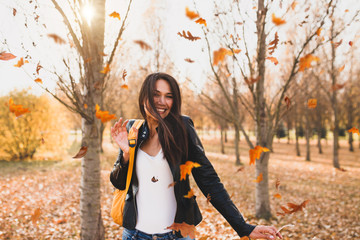 Laughing blond tooth smile attractive sexy brunette surrounded by a whirlwind of yellow autumn...