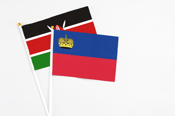 Liechtenstein and Kenya stick flags on white background. High quality fabric, miniature national flag. Peaceful global concept.White floor for copy space.