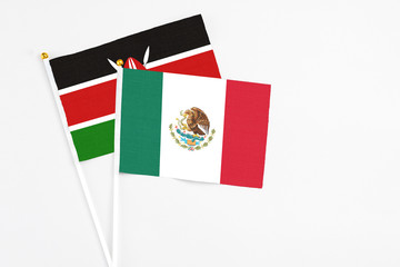 Mexico and Kenya stick flags on white background. High quality fabric, miniature national flag. Peaceful global concept.White floor for copy space.