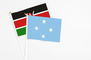 Micronesia and Kenya stick flags on white background. High quality fabric, miniature national flag. Peaceful global concept.White floor for copy space.