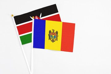 Moldova and Kenya stick flags on white background. High quality fabric, miniature national flag. Peaceful global concept.White floor for copy space.