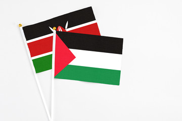Palestine and Kenya stick flags on white background. High quality fabric, miniature national flag. Peaceful global concept.White floor for copy space.