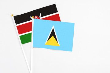 Saint Lucia and Kenya stick flags on white background. High quality fabric, miniature national flag. Peaceful global concept.White floor for copy space.