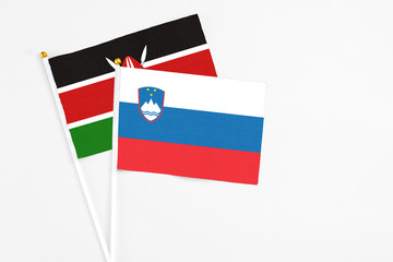 Slovenia and Kenya stick flags on white background. High quality fabric, miniature national flag. Peaceful global concept.White floor for copy space.