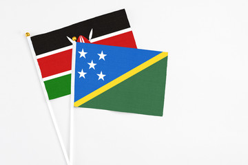 Solomon Islands and Kenya stick flags on white background. High quality fabric, miniature national flag. Peaceful global concept.White floor for copy space.