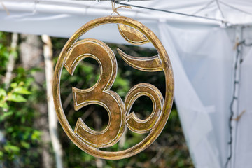 selective focus and close up of Hindu om symbol made out of metal, Hanging on the tent during a...