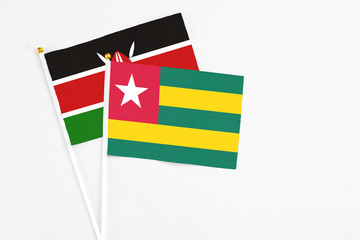 Togo and Kenya stick flags on white background. High quality fabric, miniature national flag. Peaceful global concept.White floor for copy space.
