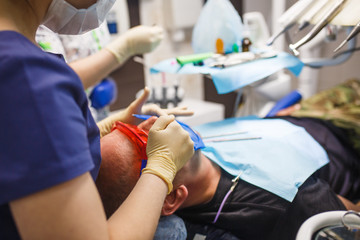 Treatment of the patient in the dentist's office close-up. The process of prosthetics and and the patient's mouth with dental instruments