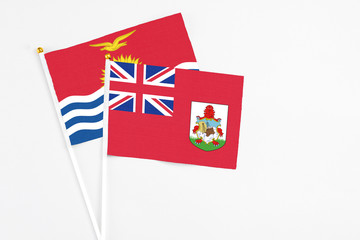 Bermuda and Kiribati stick flags on white background. High quality fabric, miniature national flag. Peaceful global concept.White floor for copy space.