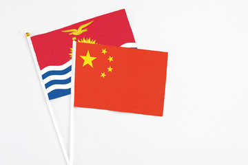 China and Kiribati stick flags on white background. High quality fabric, miniature national flag. Peaceful global concept.White floor for copy space.