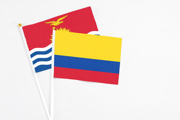 Colombia and Kiribati stick flags on white background. High quality fabric, miniature national flag. Peaceful global concept.White floor for copy space.