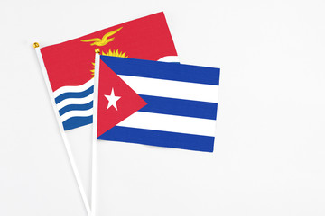 Cuba and Kiribati stick flags on white background. High quality fabric, miniature national flag. Peaceful global concept.White floor for copy space.