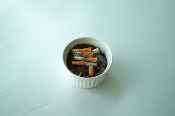 Close up ceramic bowl of cigarette ashtray