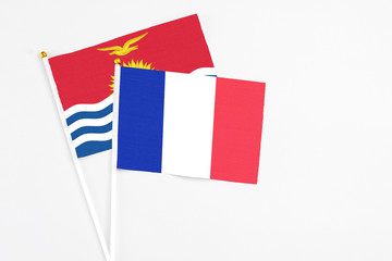 France and Kiribati stick flags on white background. High quality fabric, miniature national flag. Peaceful global concept.White floor for copy space.