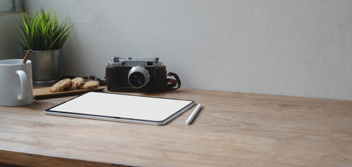 Close-up view of minimal workspace with  tablet and camera with copy space