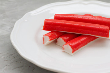 Delicious crab sticks prepared for eating. Five crab sticks on a white plate. Food on the table....