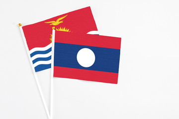 Laos and Kiribati stick flags on white background. High quality fabric, miniature national flag. Peaceful global concept.White floor for copy space.
