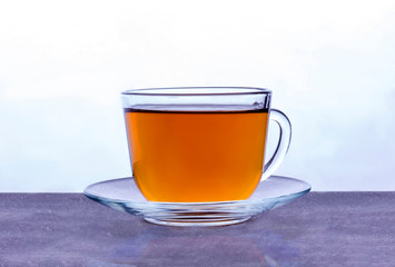 a transparent glass Cup with black tea stands at the light source