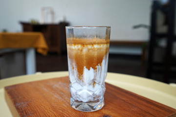 A glass of latte coffee on wooden tray table