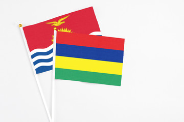 Mauritius and Kiribati stick flags on white background. High quality fabric, miniature national flag. Peaceful global concept.White floor for copy space.