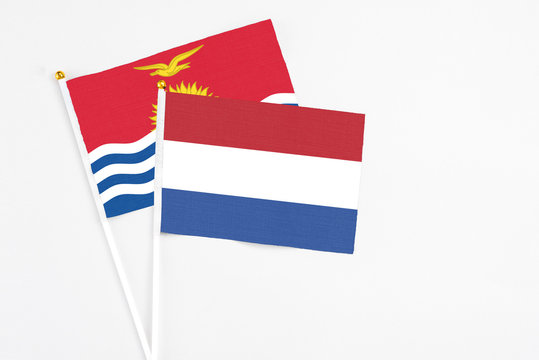 Netherlands and Kiribati stick flags on white background. High quality fabric, miniature national flag. Peaceful global concept.White floor for copy space.