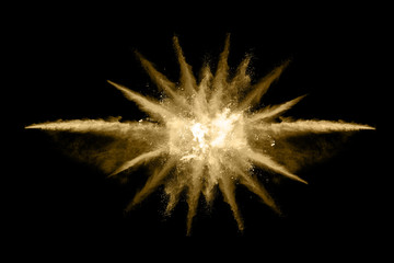 Golden powder explosion on black background. Freeze motion.