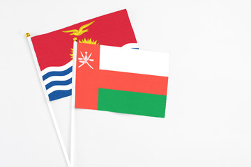 Oman and Kiribati stick flags on white background. High quality fabric, miniature national flag. Peaceful global concept.White floor for copy space.