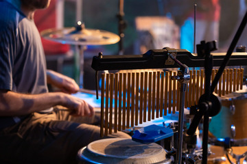 A selective focus and close-up view on professional bar chimes, drums accessories, blurry view of a...