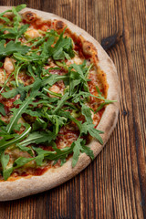 Close up of prawn and cheese pizza with a bunch of fresh arugula