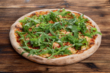 Prawn and cheese pizza with a bunch of fresh arugula