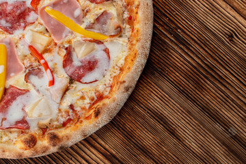 Meat pizza with ham and fresh bell pepper on wooden table