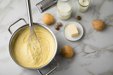 Kochtopf mit Kartoffelpüree mit Zutaten aus Kartoffeln, Milch, Salz, Butter, Muskatnuss dazu...