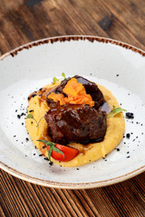 Demi-glace beef with gravy and mashed potatoes on rustic plate and wooden table