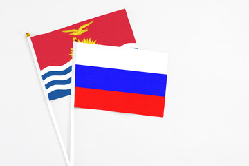 Russia and Kiribati stick flags on white background. High quality fabric, miniature national flag. Peaceful global concept.White floor for copy space.